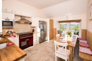 uma cozinha com uma mesa de jantar e uma cozinha com um fogão em The Old Farmhouse em Balloch