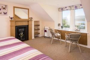 Un dormitorio con una cama, un escritorio y una chimenea. en The Old Farmhouse, en Balloch