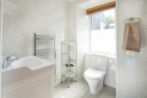 Un baño con lavabo, inodoro y ventana. en The Old Farmhouse, en Balloch 37 fotos más