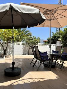 アルビールにあるVista Bahia II Apartmentのパティオ(椅子2脚、テーブル、パラソル付)