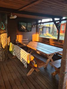a picnic table and bench in a cabin at Domek Wakacyjny Maciuś 48 in Głębokie