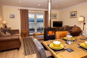 a living room with a table and a fireplace at Braemore Cottage in Tarbert