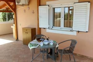 a table and chairs in a room with a window at En Zar Ξυλόκαστρο in Áno Kamárion +12 photos