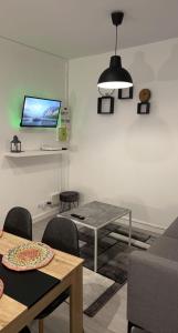 Coudekerque-BrancheAppartement moderne refait à neuf proximité centre ville et plage的客厅配有桌子,墙上配有电视