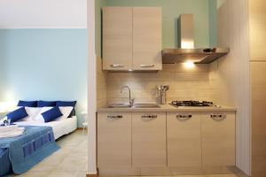 una cocina con fregadero y un sofá en una habitación en Taormina Studio Apartments, en Giardini Naxos