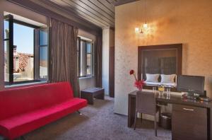 a living room with a red couch and a desk at Aion Luxury Hotel in Nafplio