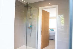 a shower with a glass door in a bathroom at The Cedars in West Clandon