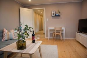 a living room with a couch and a table with wine glasses at Moderne Wohnung im Grünen mit privatem Garten in Donaueschingen