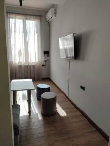 a living room with a television and a table and stool at Lovely apartment in Yerevan - close to city center in Yerevan