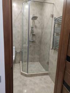 a shower with a glass door in a bathroom at Lovely apartment in Yerevan - close to city center in Yerevan