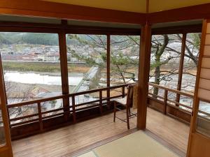 Habitación con ventanas y balcón con silla. en En Yoshino - Vacation STAY 13165, en Kami-ichi