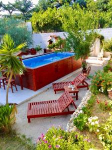 einem Pool mit roten Bänken und einem Tisch und einem sidx sidx sidx sidx sidx in der Unterkunft Villa Zagara in Gioiosa Ionica