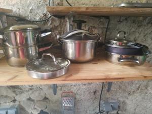 a bunch of pots and pans on a shelf at Eco Yourte Lac du Bourget in Conjux