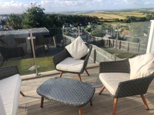 a patio with two chairs and a table and a chair at Halcyon - 4 Bed Luxury Holiday home in Salcombe (Sleeps 8) in Salcombe