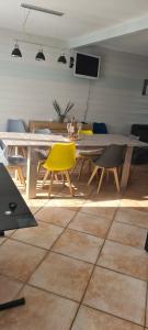 una sala da pranzo con tavolo e sedie gialle di CHALET ANTLANA maison chaleureuse a Signy-lʼAbbaye