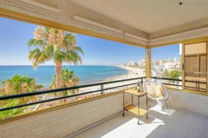 a room with a balcony with a view of the beach at Apartamento del Mar - Playa Muchavista in El Campello