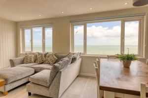 a living room with a couch and a table at Granville Marina: Stunning sea view property with easy parking in Ramsgate