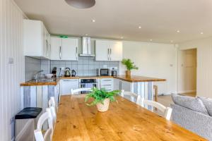 een keuken en eetkamer met een houten tafel bij Granville Marina: Stunning sea view property with easy parking in Ramsgate