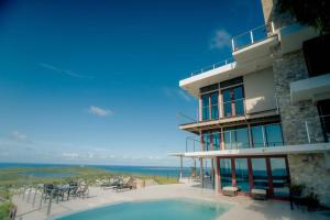 a building with a swimming pool next to the ocean at Happy Days Villa A in Fajardo +41 photos