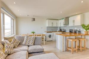 een woonkamer met een bank en een keuken bij Granville Marina: Stunning sea view property with easy parking in Ramsgate