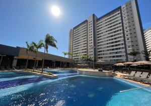 a large swimming pool in front of a large building at Enjoy Solar das Águas Park Resort in Olímpia