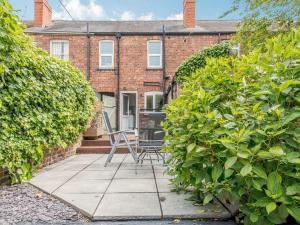 a house with a patio with chairs in front of it at Stylish Uphill Townhouse in Lincoln