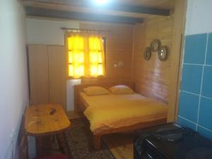 um pequeno quarto com uma cama e uma janela em Apartmani Gnezdo em Nova Varoš