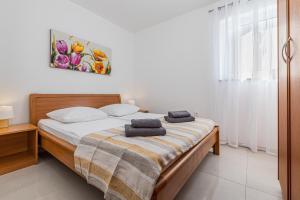a bedroom with a bed with two towels on it at Apartment Bellistra Rabac in Rabac