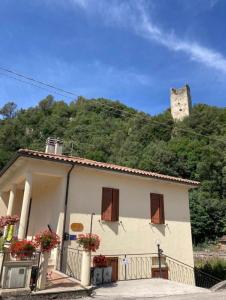 una piccola casa bianca con un castello su una collina di La Casa dei Nonni a Torre Orsina