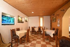 a dining room with tables and chairs and a tv at Komovi Eko katun in Andrijevica