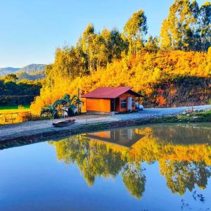 a small cabin next to a body of water at Cabana Brisa Serrana - Urubici-SC in Urubici