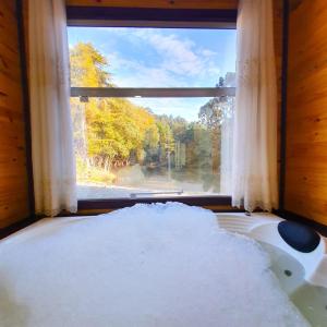a large window with a pile of snow in front of a bath tub at Cabana Brisa Serrana - Urubici-SC in Urubici +28 photos