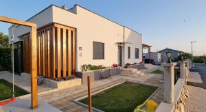 a house with wooden pillars on the side of it at Yellow dream in Murvica
