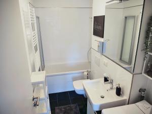 Baño blanco con lavabo y aseo en Appartement SCHILLER I - Erfurt Zentrum en Erfurt