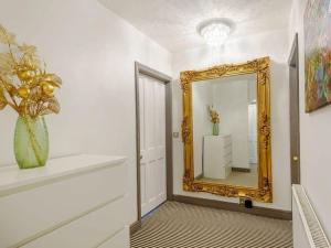 einen Flur mit einem Spiegel und einer Vase auf einem Regal in der Unterkunft Stylish Uphill Townhouse in Lincoln + 27 Fotos