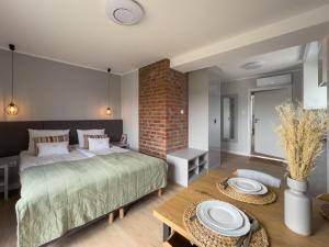 a bedroom with a bed and a brick wall at Vincent Apartamenty Darłówek in Darłowo