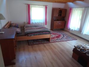 a bedroom with a bed and a desk and windows at Chata v Rajeckej kotline - Malá Čierna in Rajec