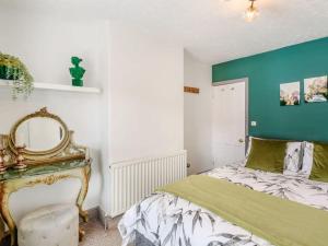 ein Schlafzimmer mit einem Bett und einer grün-weißen Wand in der Unterkunft Stylish Uphill Townhouse in Lincoln