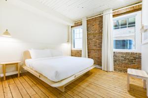 - une chambre avec un lit et un mur en briques dans l'établissement La Maison des Lofts - Par les Lofts Vieux-Quebec, à Québec