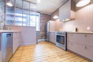 a kitchen with wooden floors and a brick wall at La Maison des Lofts - Par les Lofts Vieux-Quebec in Quebec City