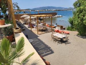a beach with tables and chairs and a body of water at Central Park Apartment in Volos