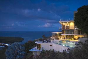 a house with a swimming pool at night at Happy Days Villa A in Fajardo