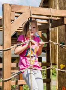 a young girl sitting on a rope swing at Domek "PRZYBYSZÓWKA" Bieszczady in Mchawa