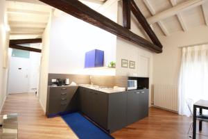 a kitchen with black cabinets and a blue rug at Rio Fiol Apartment in Verona