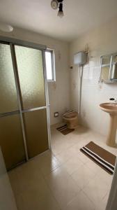 a bathroom with a shower and a toilet and a sink at Apartamento com dois quartos no fragata in Pelotas