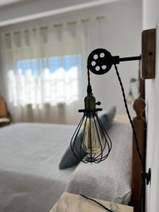 una lámpara colgada en el costado de una cama en Apartamentos Lalola en Cabezuela del Valle