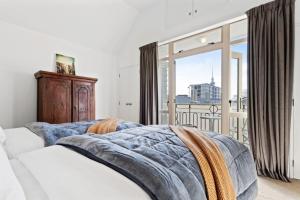 a bedroom with a bed and a large window at CBD Spacious 3 Storey Terrace House with Courtyard in Auckland