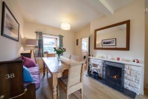 a living room with a table and a fireplace at Immaculate 3 Bedroom House in Blair Atholl in Blair Atholl