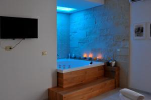 a bathroom with a tub with a tv on a wall at BluOtranto in Otranto