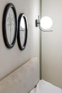 deux miroirs suspendus sur un mur à côté d'un canapé dans l'établissement Appartamento Vert, à Diano Marina